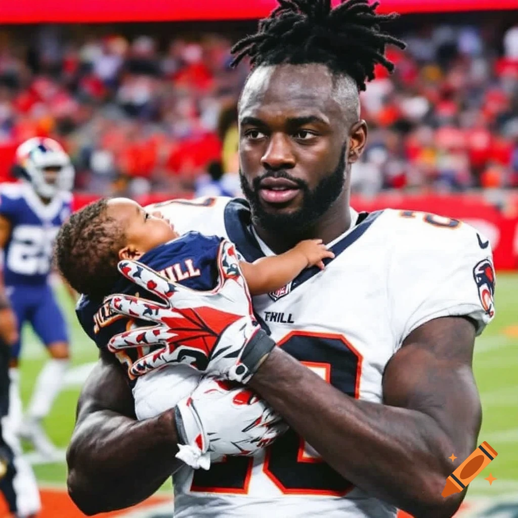 Football player holding a baby on the field