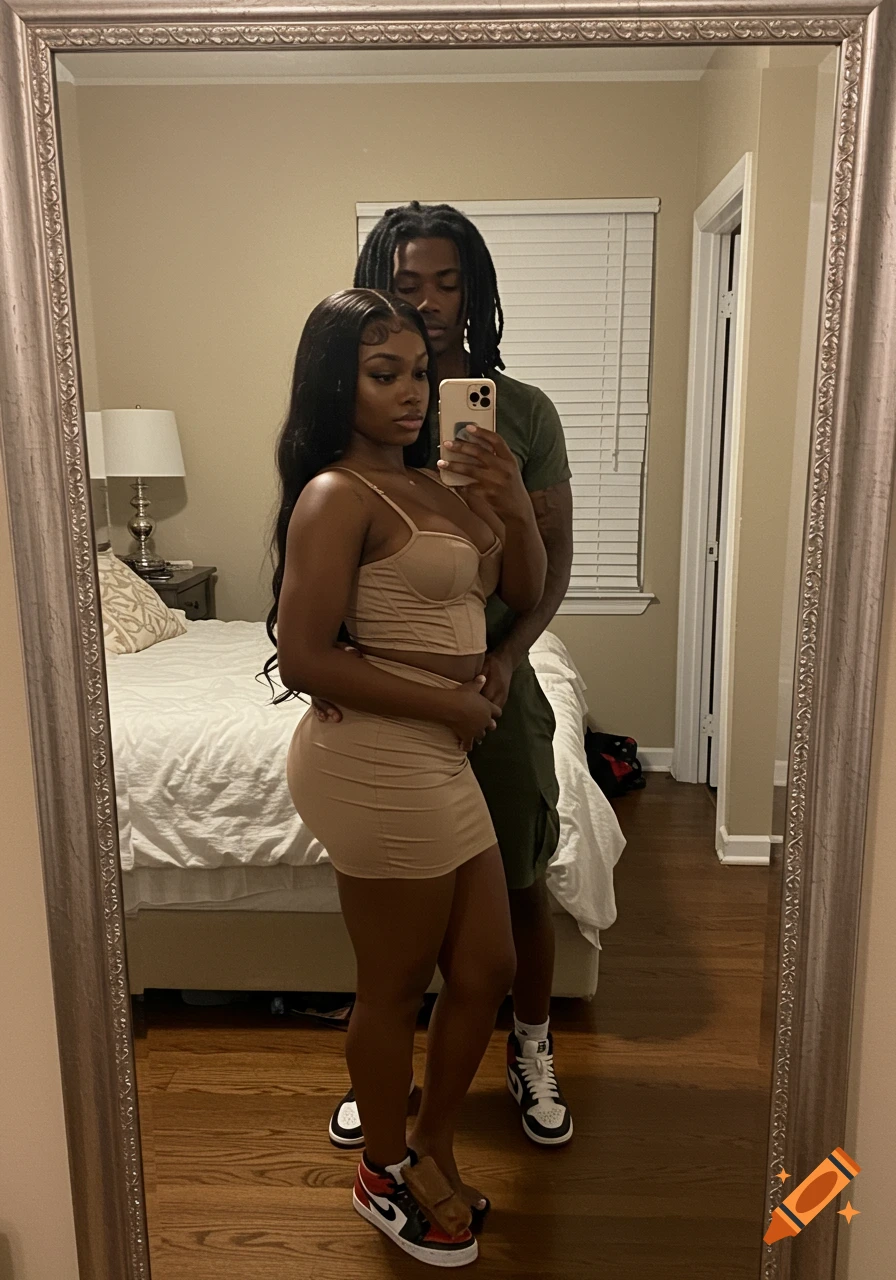 A woman takes a mirror selfie with her partner embracing her from behind in a bedroom.