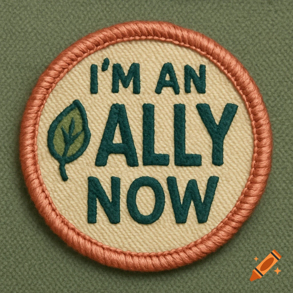 A close-up of a circular embroidered patch with a coral stitched border and a beige background. It says 'I'M AN ALLY NOW' in teal text, with a green leaf symbol.
