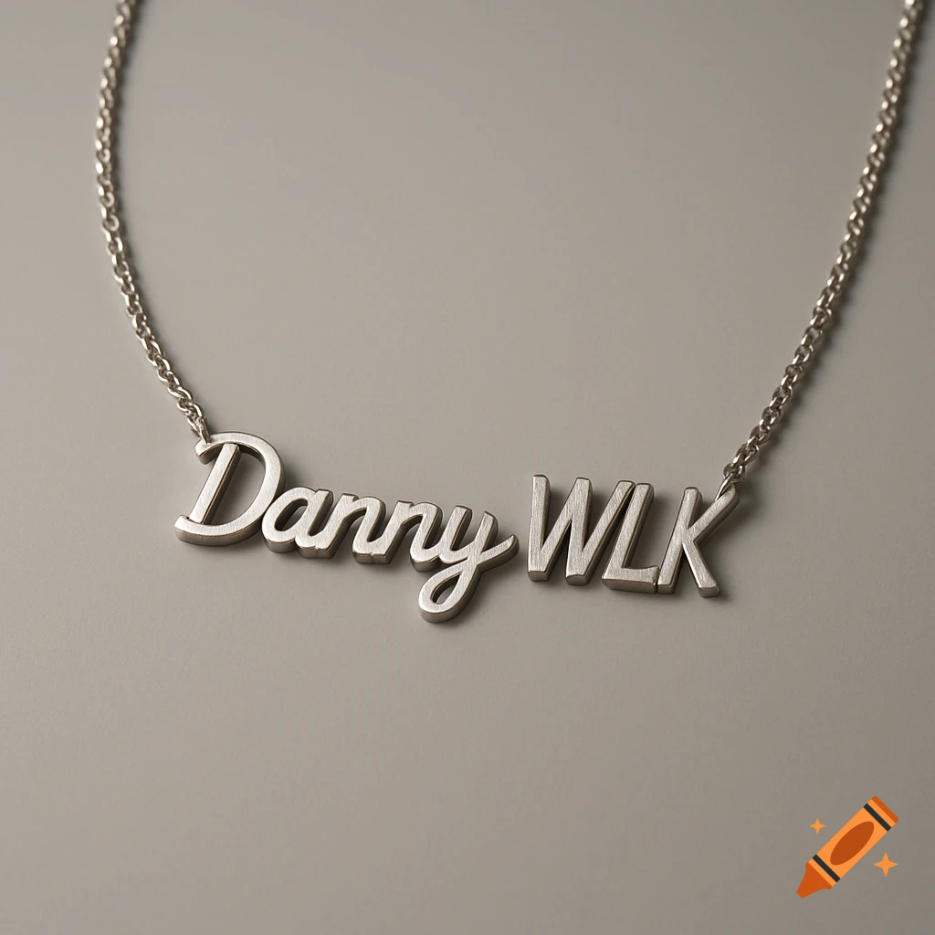 A minimalist silver chain necklace with "Danny WLK" spelled out in two different fonts, lying on a plain gray surface.