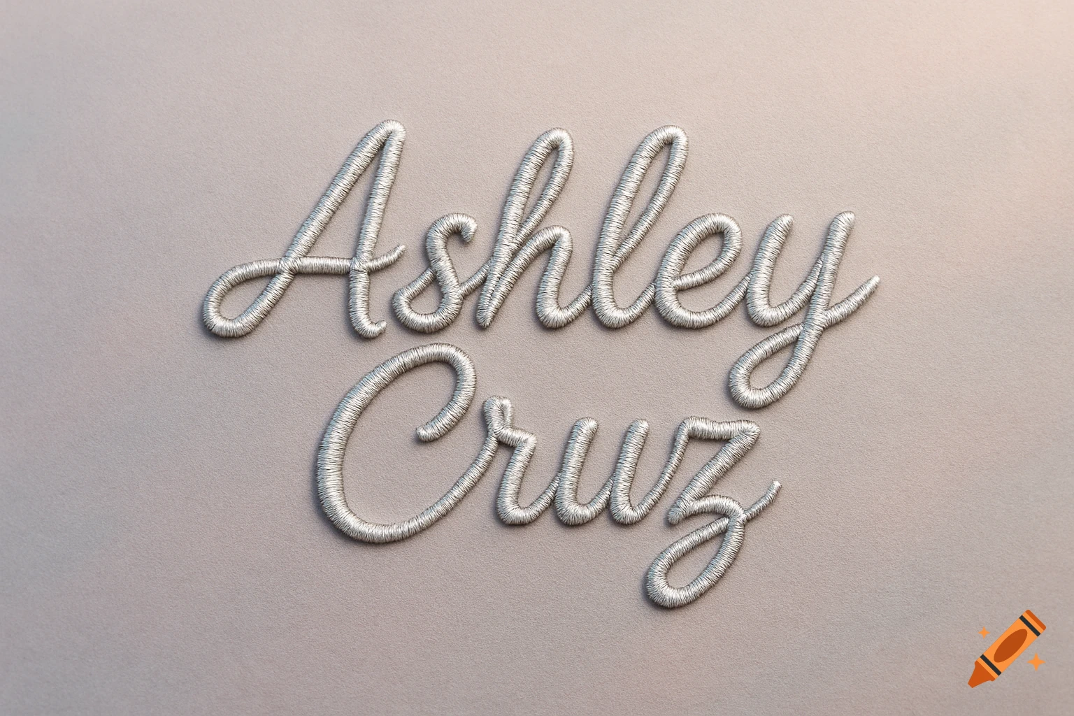 Silver embroidered text "Ashley Cruz" on a light gray fabric background.