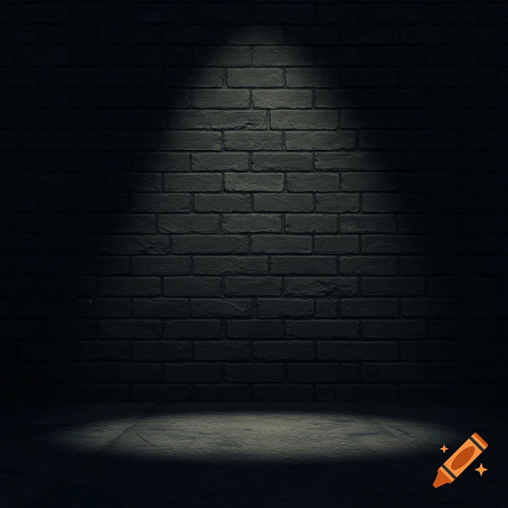 A dark grey brick wall illuminated by a bright spotlight, with a subtle glow on the concrete floor.