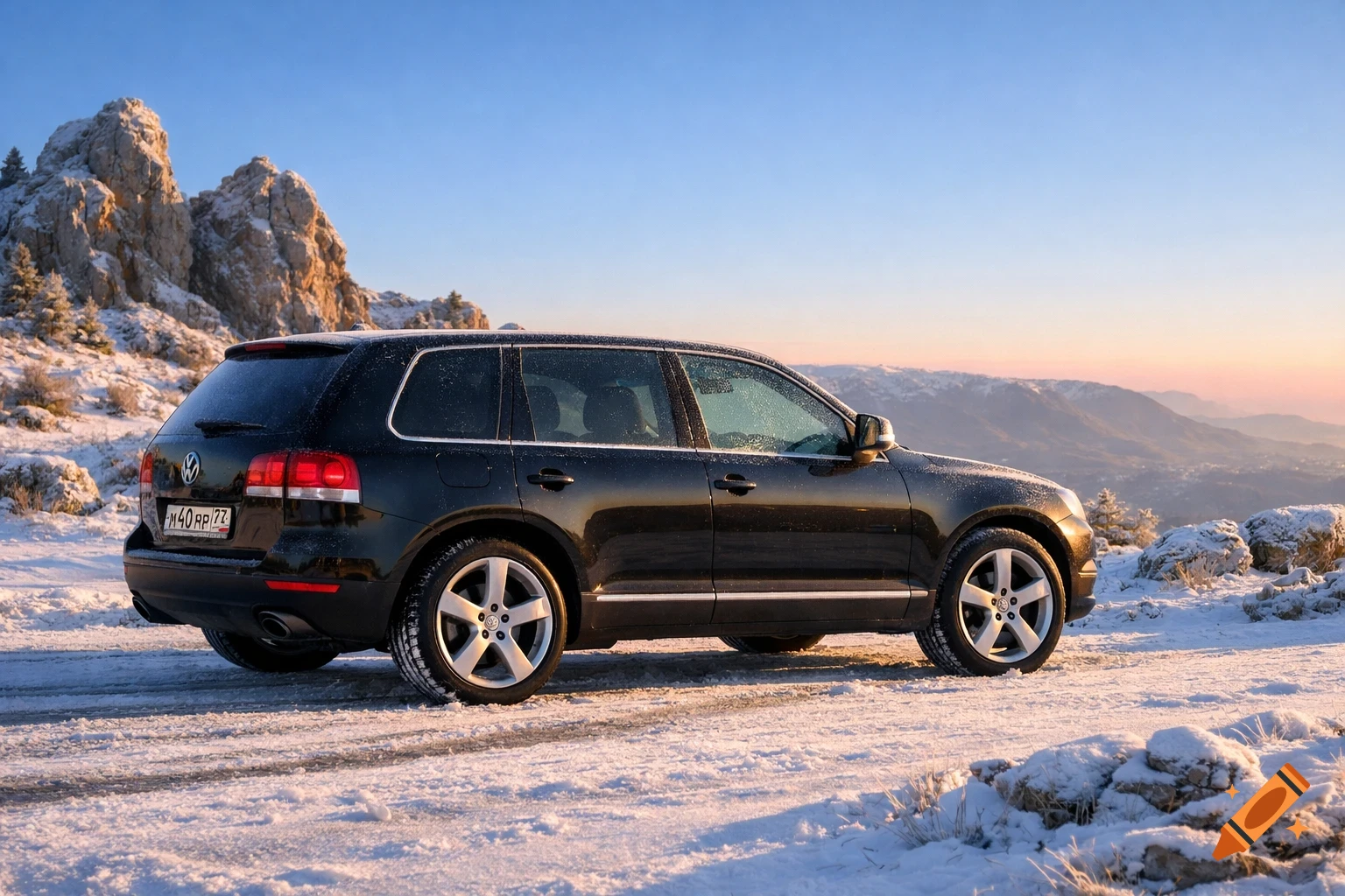A black Volkswagen Touareg SUV parked on a snowy mountain road at sunrise, with rocky peaks and valleys in the background.