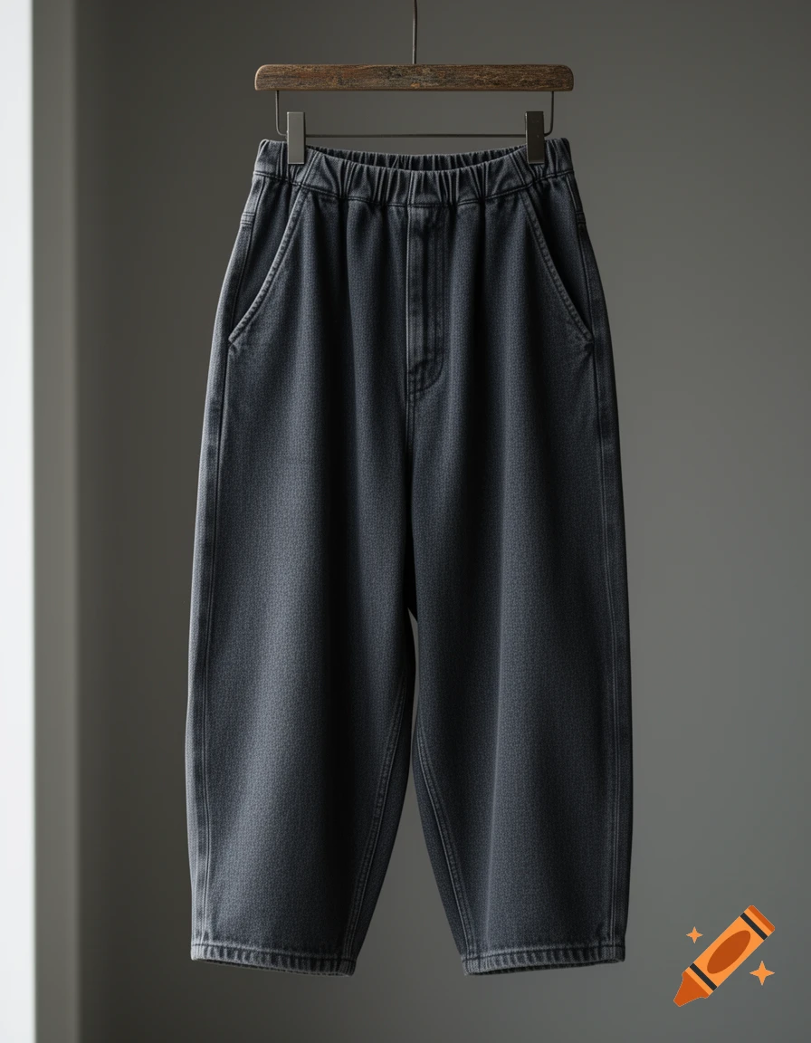 Dark grey baggy wide-leg pants on a wooden hanger against a muted background.