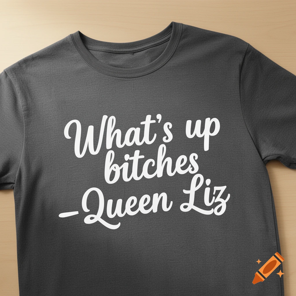 A dark gray t-shirt with the white text 'What's up bitches -Queen Liz' laid flat on a wooden surface.