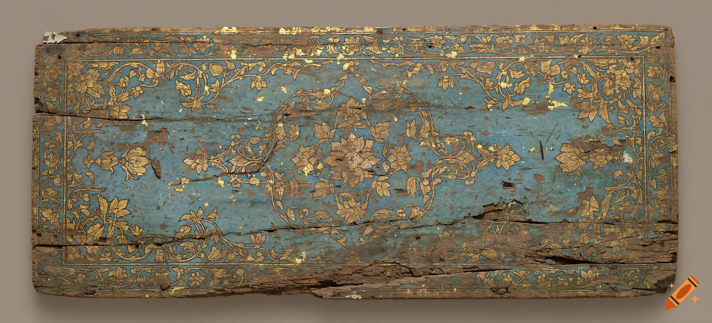 An old, weathered wooden panel with faded blue paint and remnants of gold leaf floral patterns.