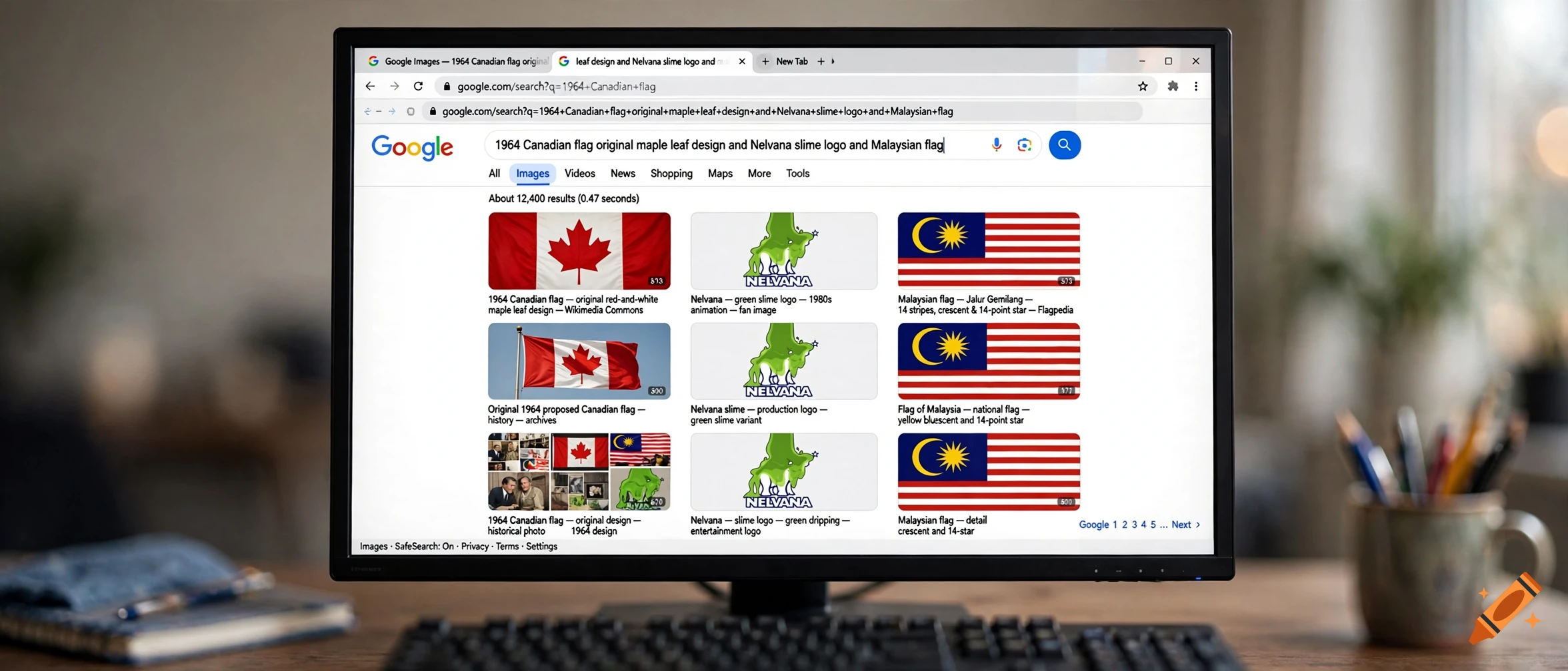 A computer monitor displaying a Google image search for historical Canadian flags, the Nelvana logo, and Malaysian flags, on a wooden desk.