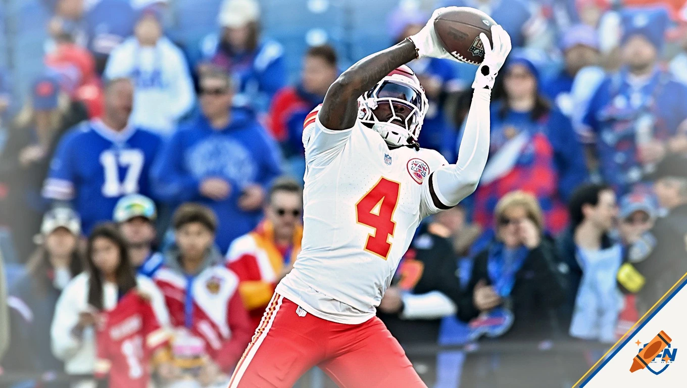 American football player in a white jersey with the number 4, wearing a helmet and white gloves, catching a football amidst a blurred stadium crowd.